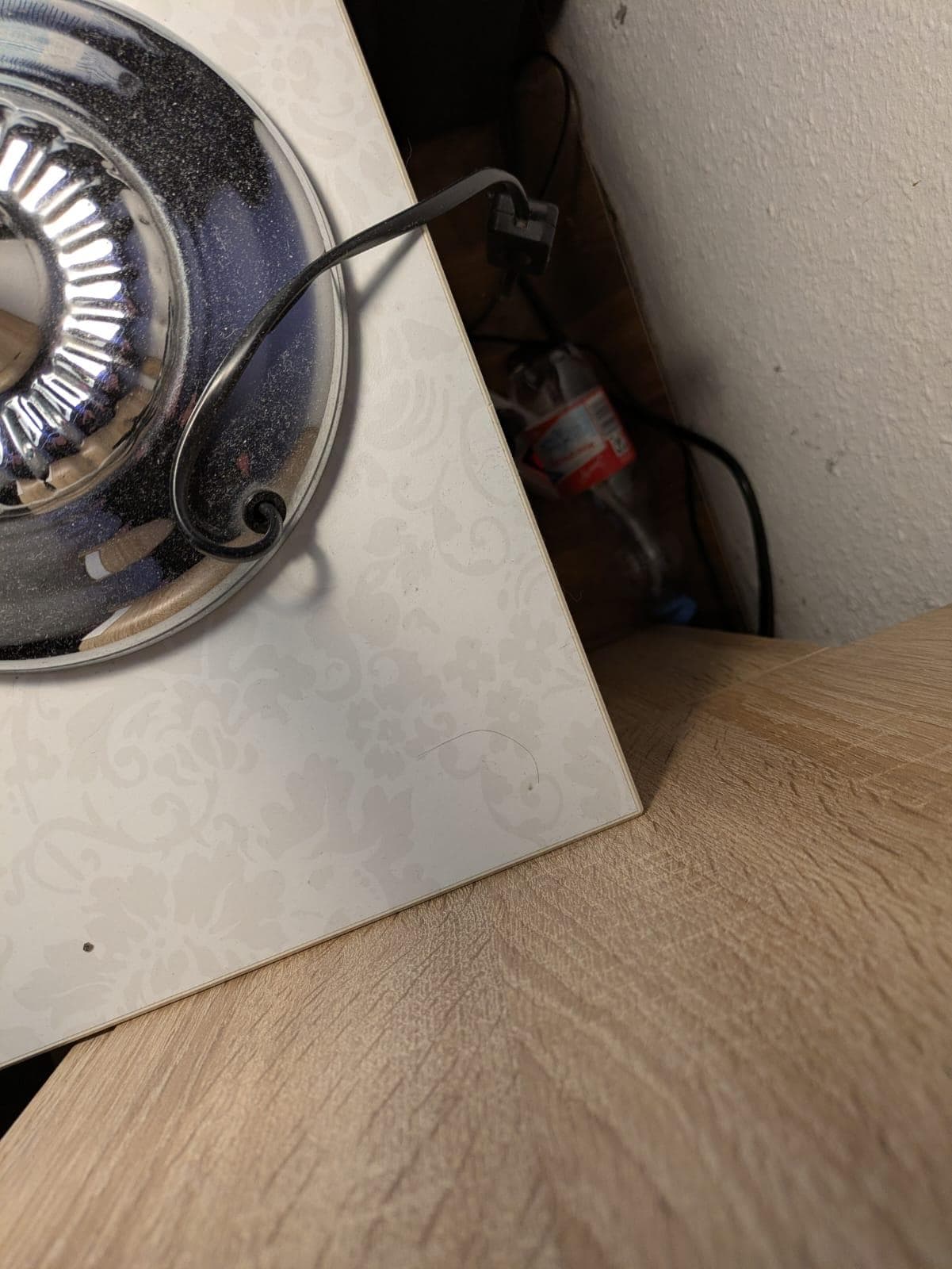 Leere Flasche hinter dem Nachtschrank 