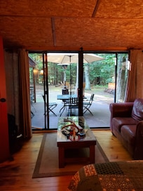 Sitting area of second room -- outdoor table and patio heater on deck visible beyond