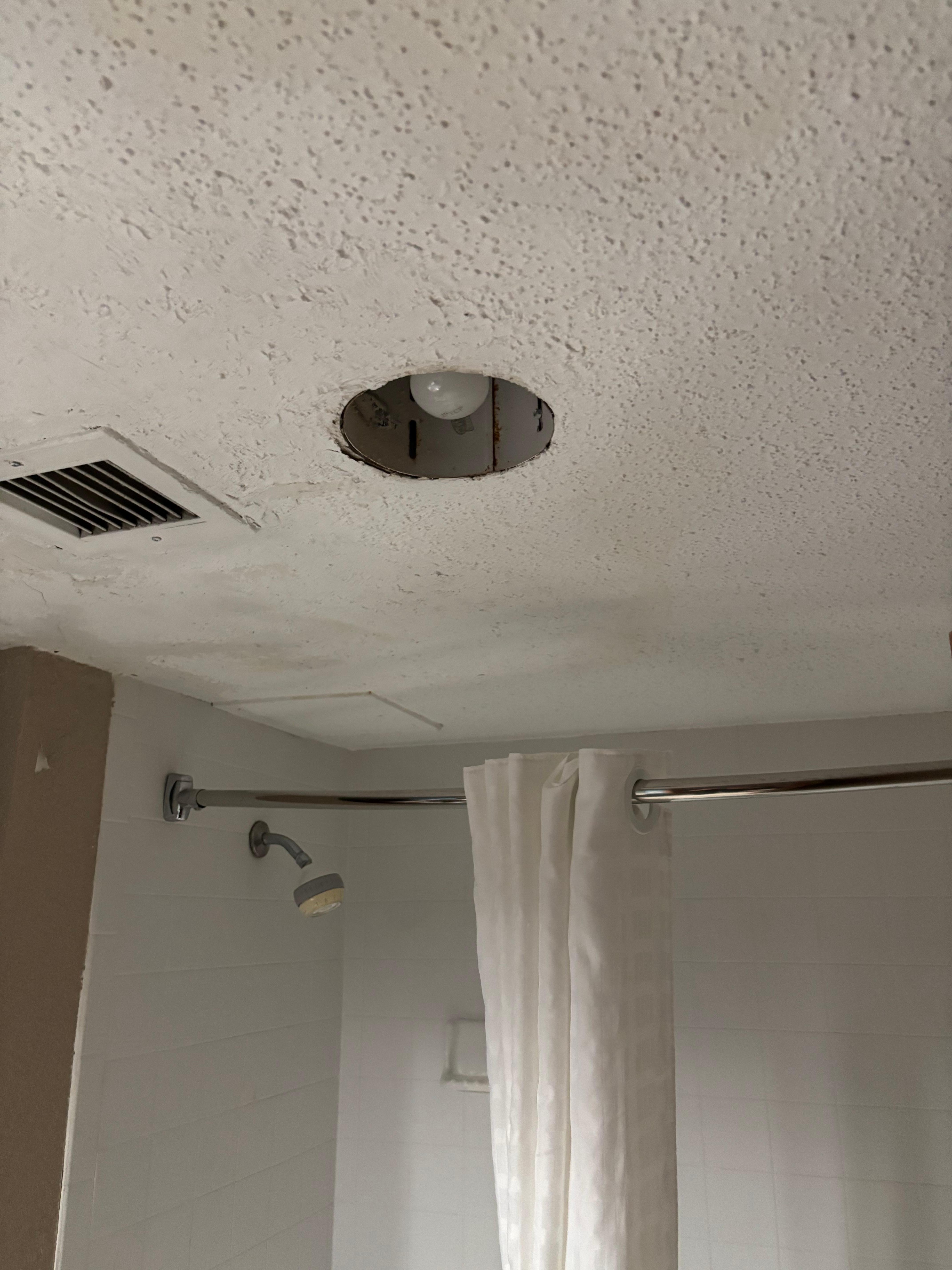 Parts of light missing. Cracks in ceiling and poorly repaired. 