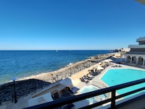 View of outdoor pool and sea from the balcony