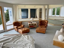 Looking from the primary bedroom on the second floor across the atrium and into the primary bathroom. Note that this area is all open and you must pass through this bedroom to reach one of the bedrooms on the second floor.