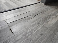 Cracked flooring and trip hazard. It bent when we walked on it.
