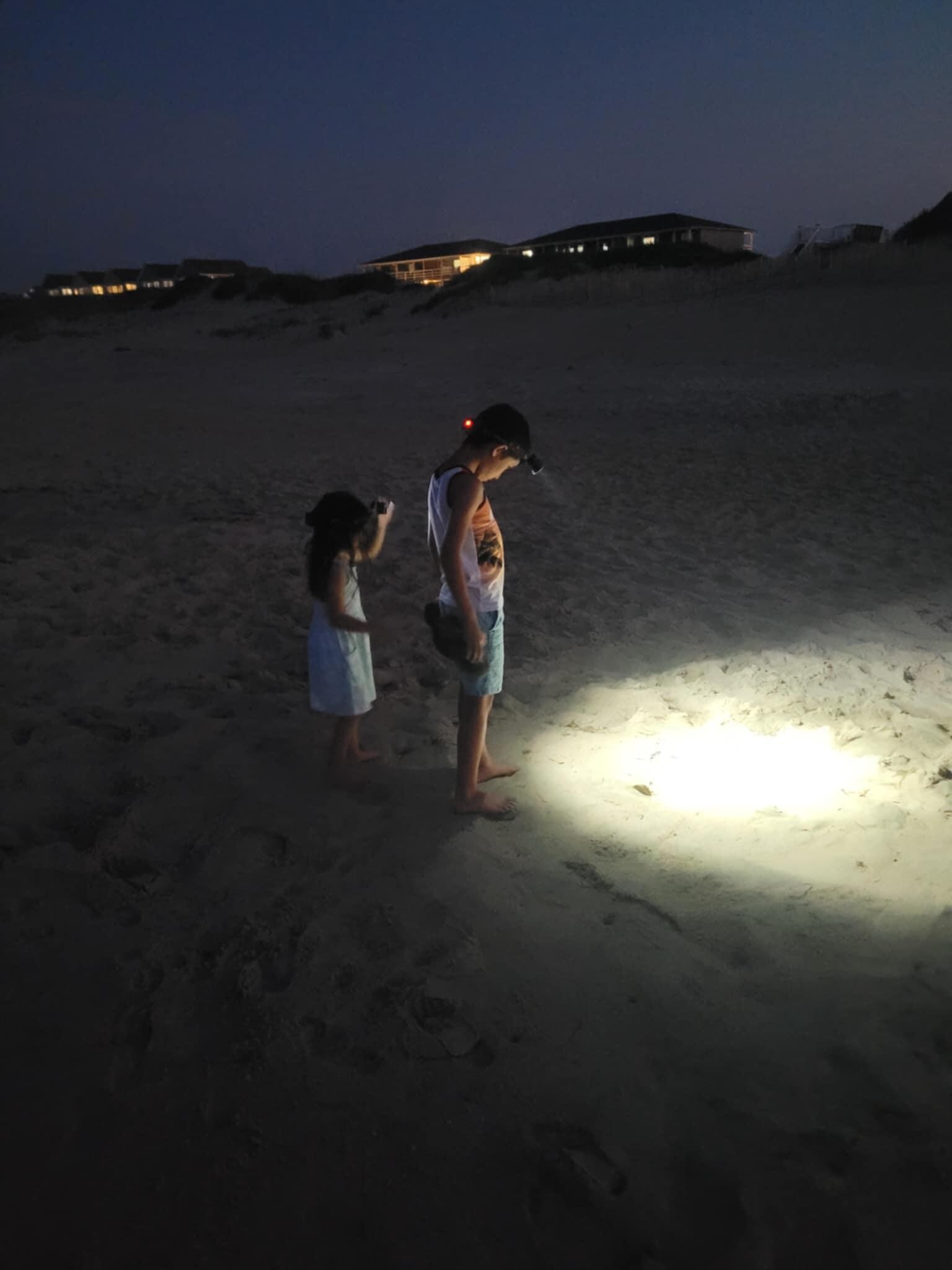 Kids walking the beach with headlamps!