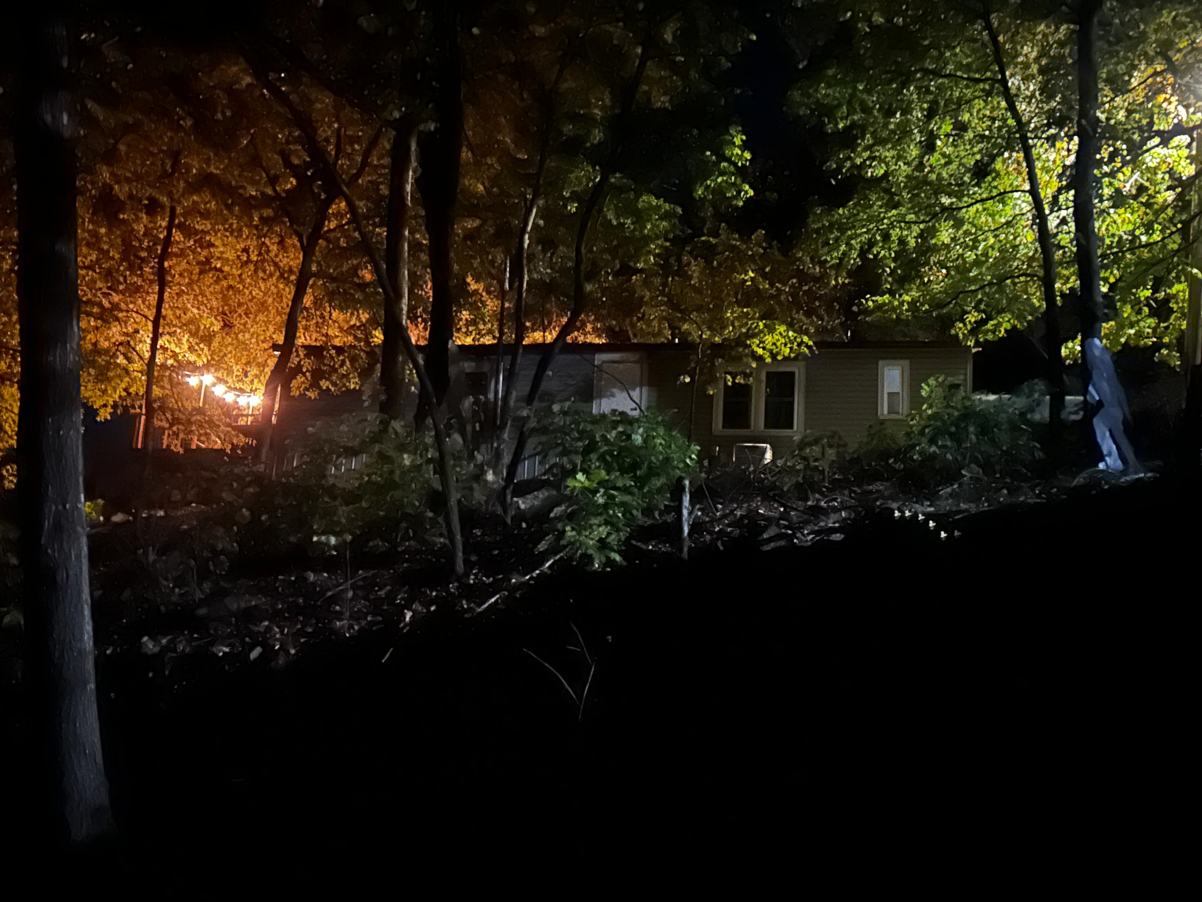 Back view of cottage from fire pit with deck lights on the left