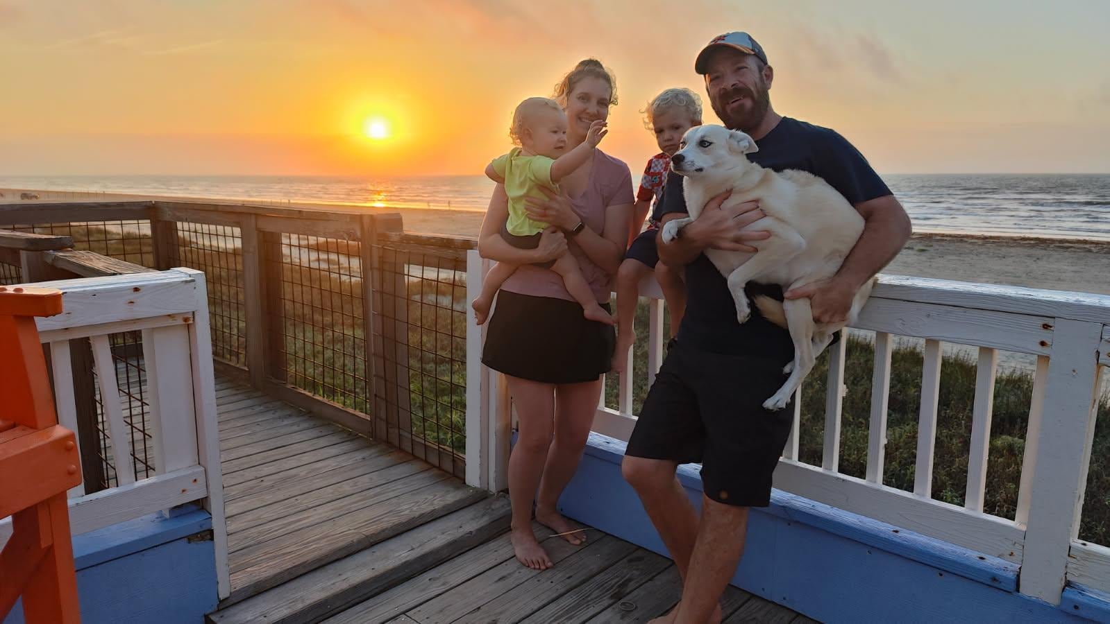 Happy family enjoying a beautiful beach sunrise 