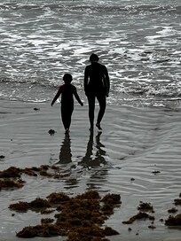 My daughter taking my granddaughter out in wetsuits.