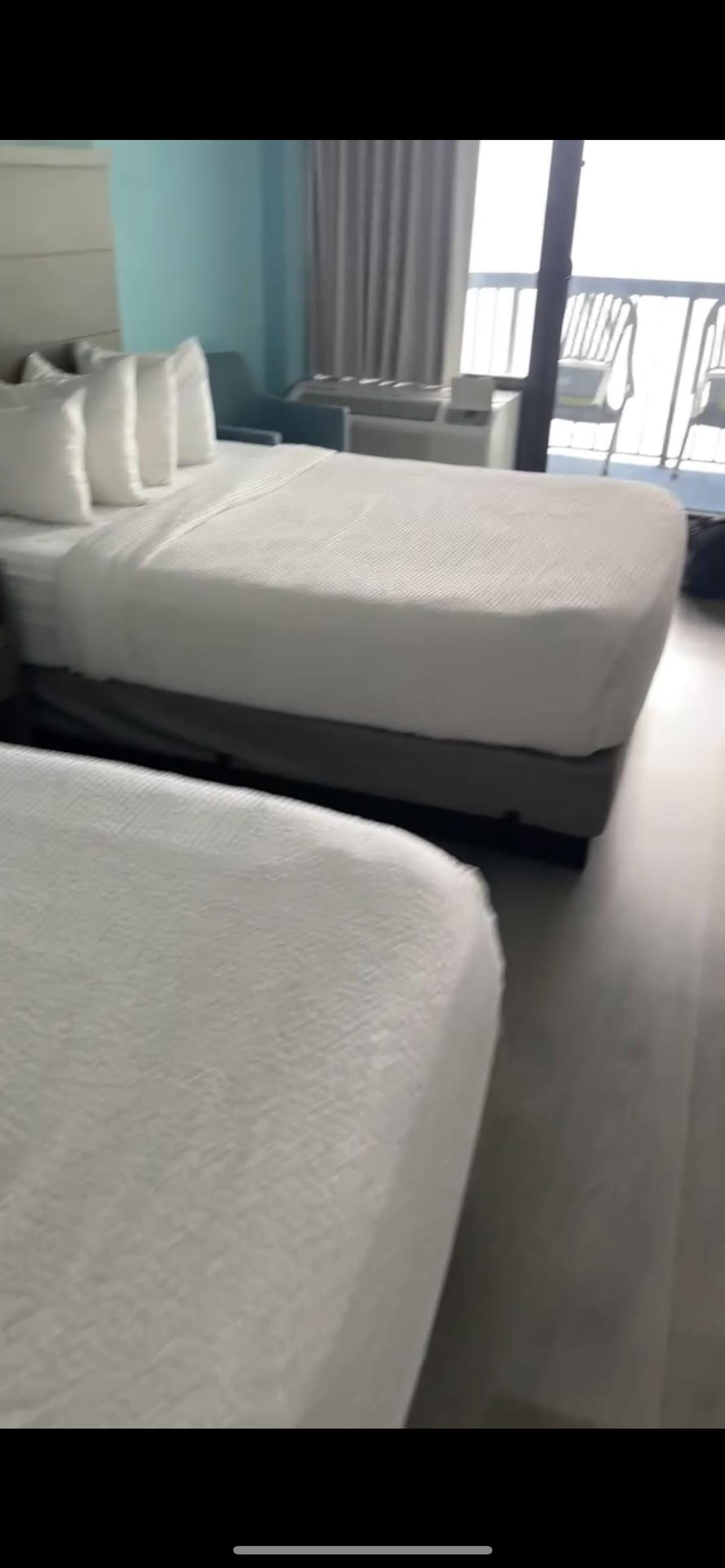 2 beds w/nightstand between and chair on other side next to A/C