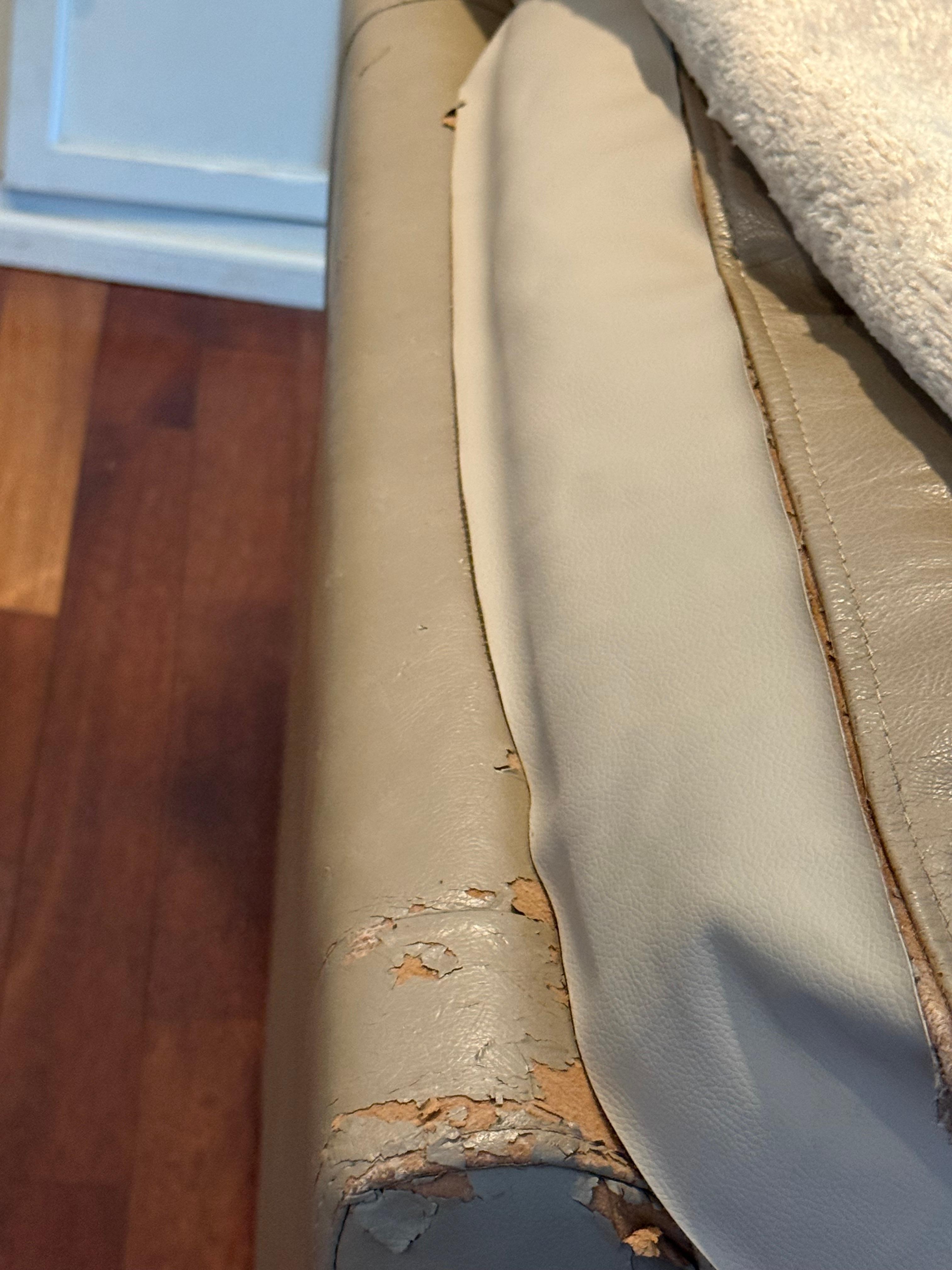 One of the two ripped love seats which was covered by a ratty looking blanket 