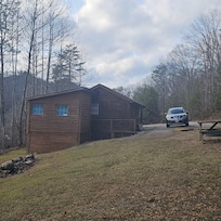 View looking from yard toward cabin and driveway coming into cabin
