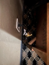 Used condoms and condom wrapper behind the nightstand next to the bed.