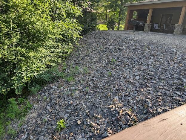 View from the deck toward the patio.  The drop-off is covered in rocks.