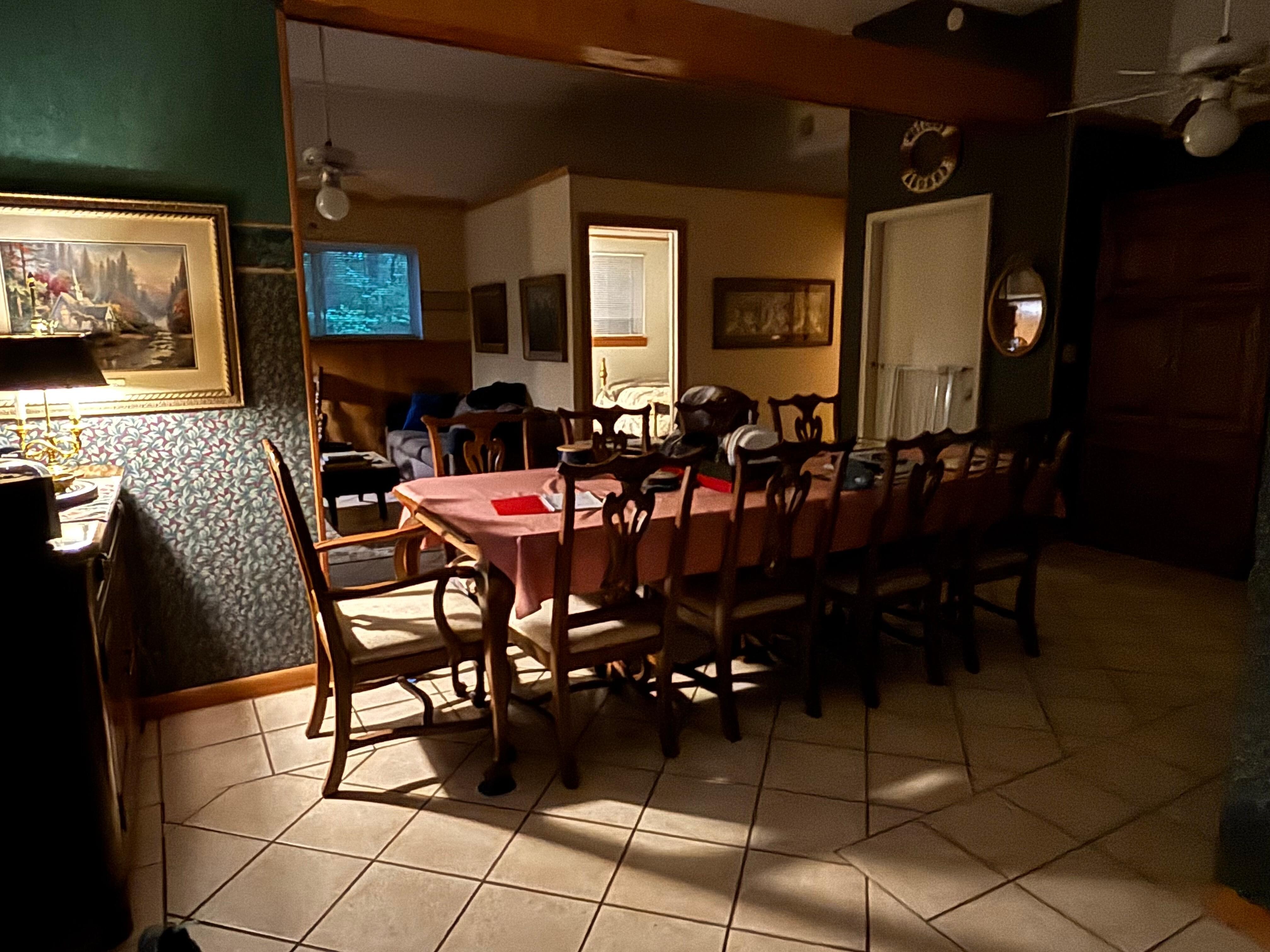 View of the comfortable dining room space with the living room area and one bedroom in the background. View is from the entry way. Great space for multiple people! 