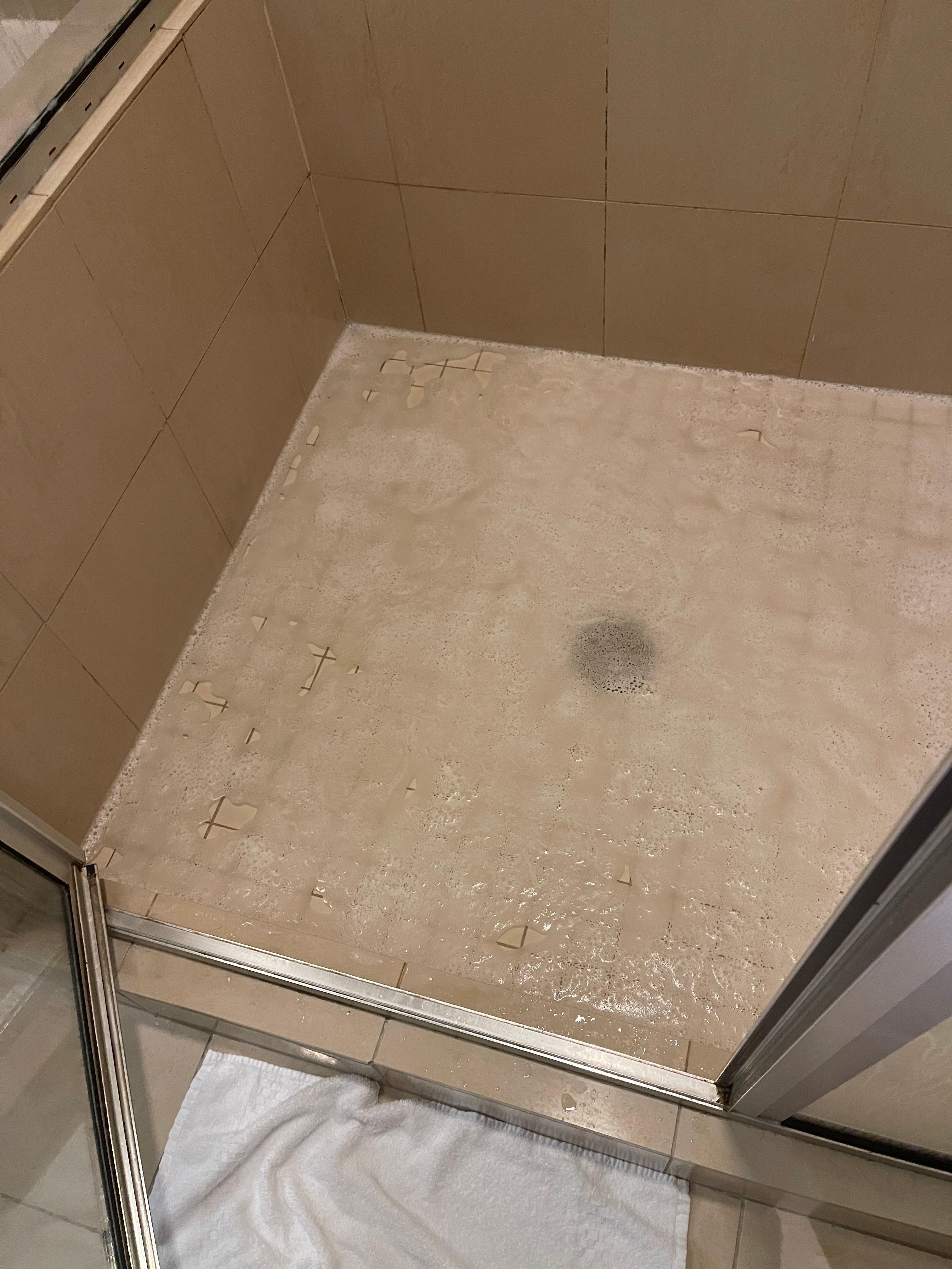Dirty shower water filling up to our ankles
