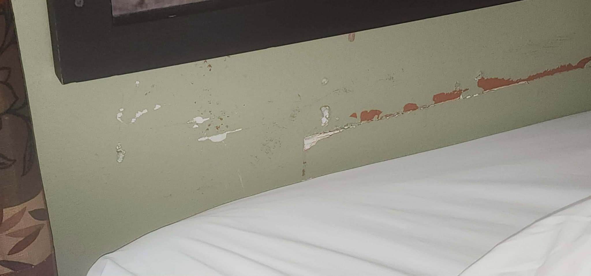 The wall behind the bed.