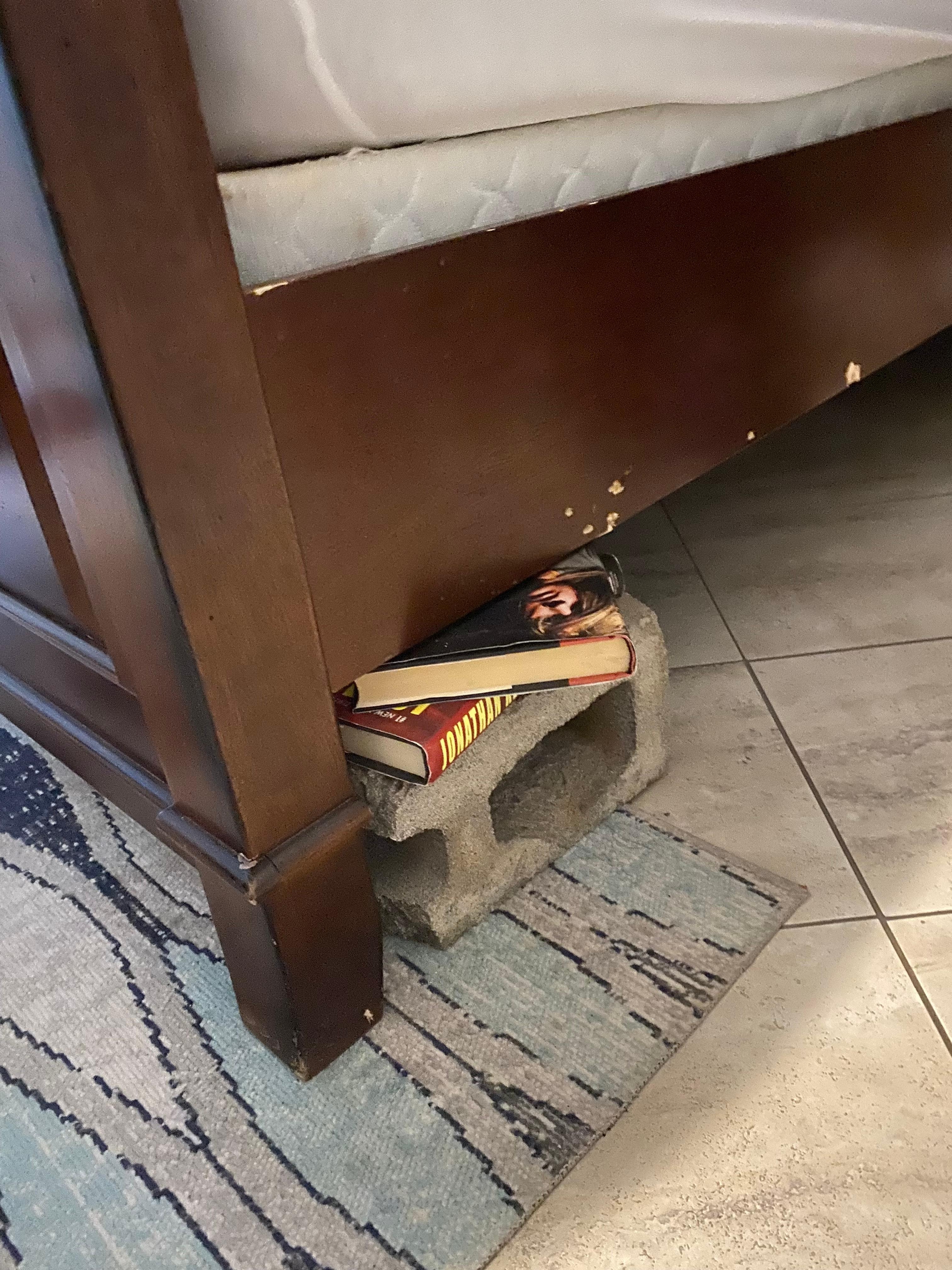 Cinder block and old books supporting bed