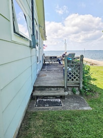 Cute little side porch which breaks the wind for sitting outside.