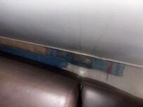 Towels rolled up behind the couch. Clearly the owner knows of this situation despite her claims she didn't.