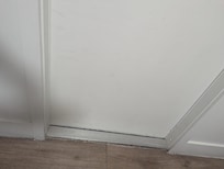 Mildew and dirt around baseboards and entry door