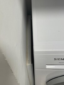 Dirt and dust along the side of the washer