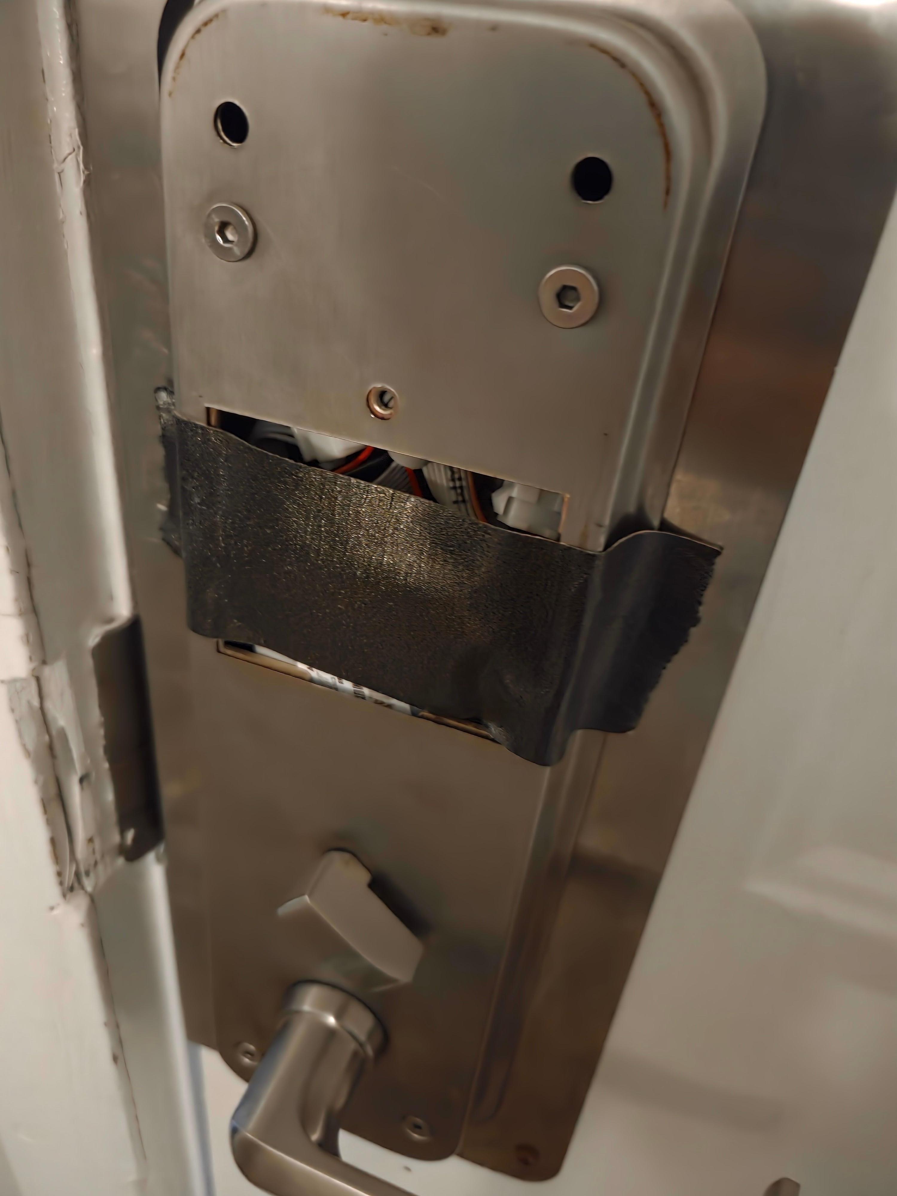 Room side view of door lock covered with duct tape