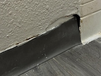 Hikes in the wall on top of bathroom baseboard where it met tub tile.