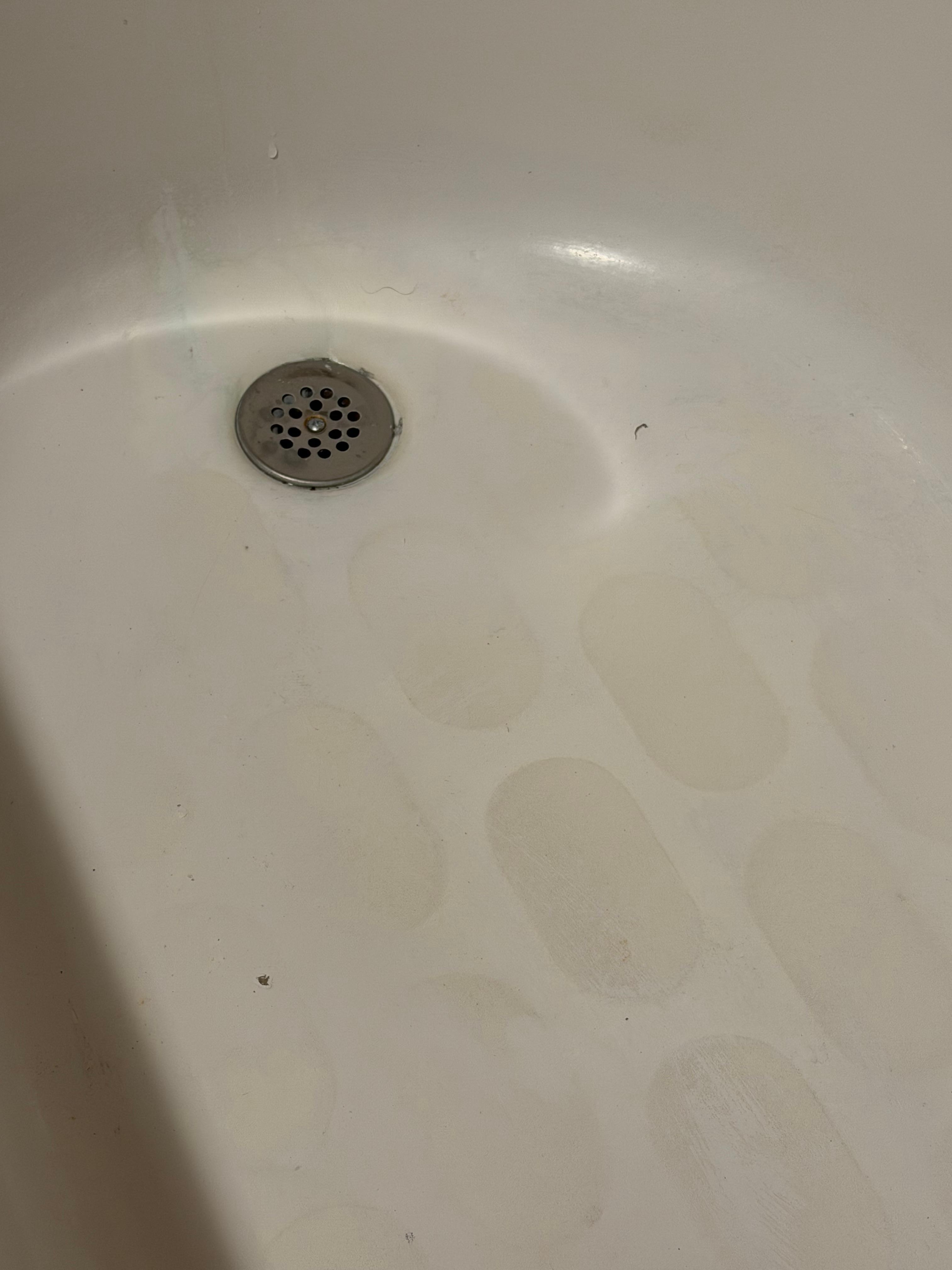 Soap scum and multiple hairs throughout the tub 
