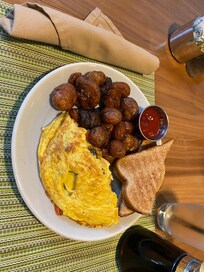 Omelet, toast, and two types of potatoes