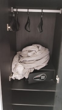 No interior do guarda roupa tinha roupa de cama suja que parecia ser do hóspede anterior