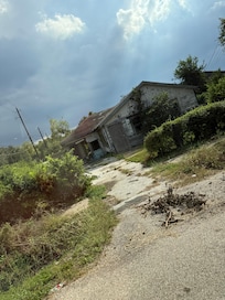 Directly across the street, condemned house with homeless hiding in back yard.