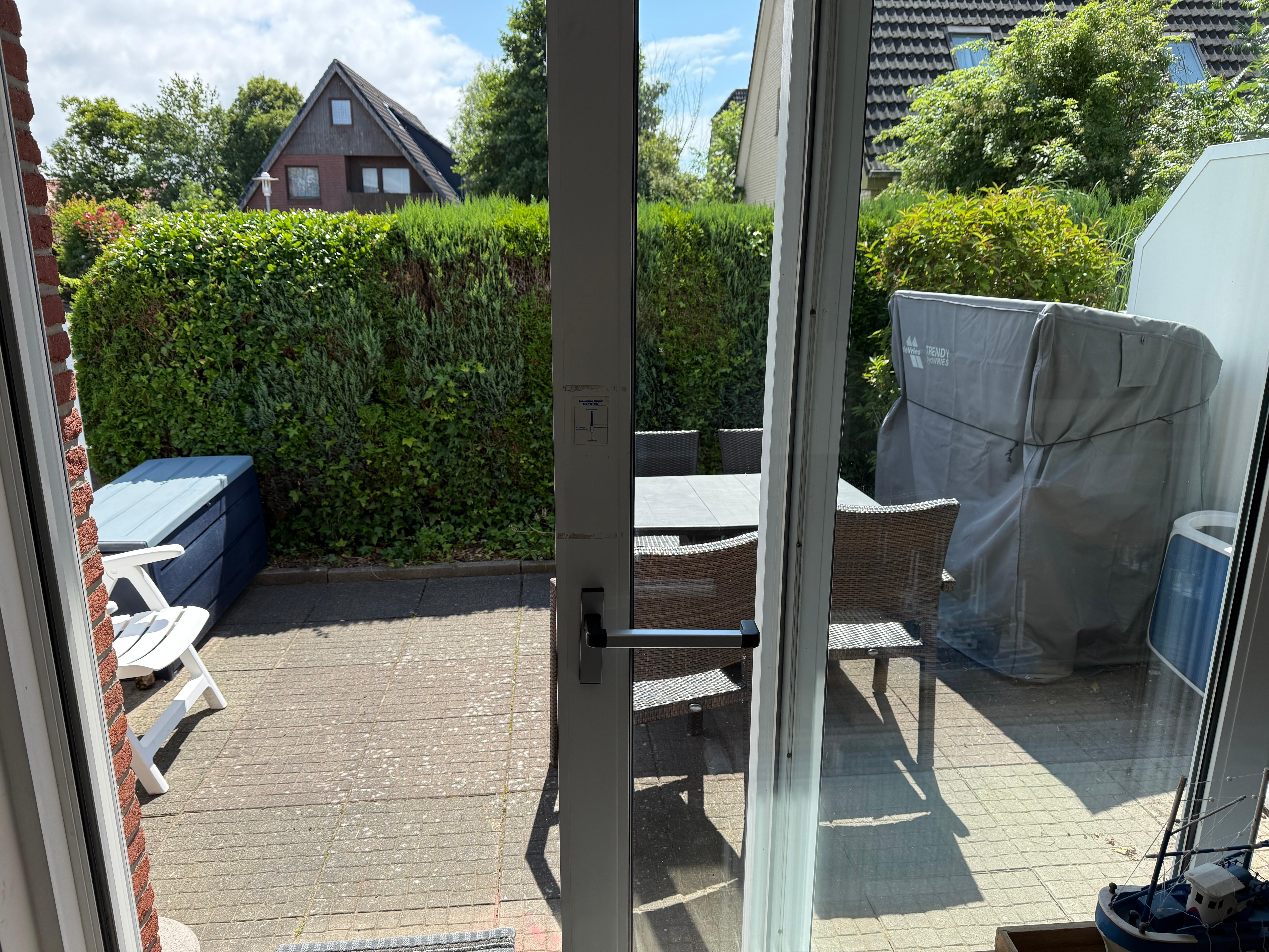 Terrasse mit Strandkorb und liege Tisch und Stühle.