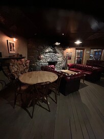 Cozy bar with couches and a fireplace.