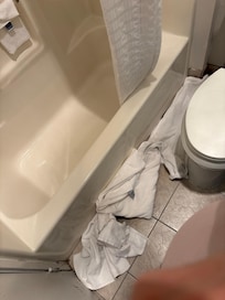 Water on the floor due to the damages of the curtain rod.