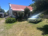 Old cortina parked in front lawn