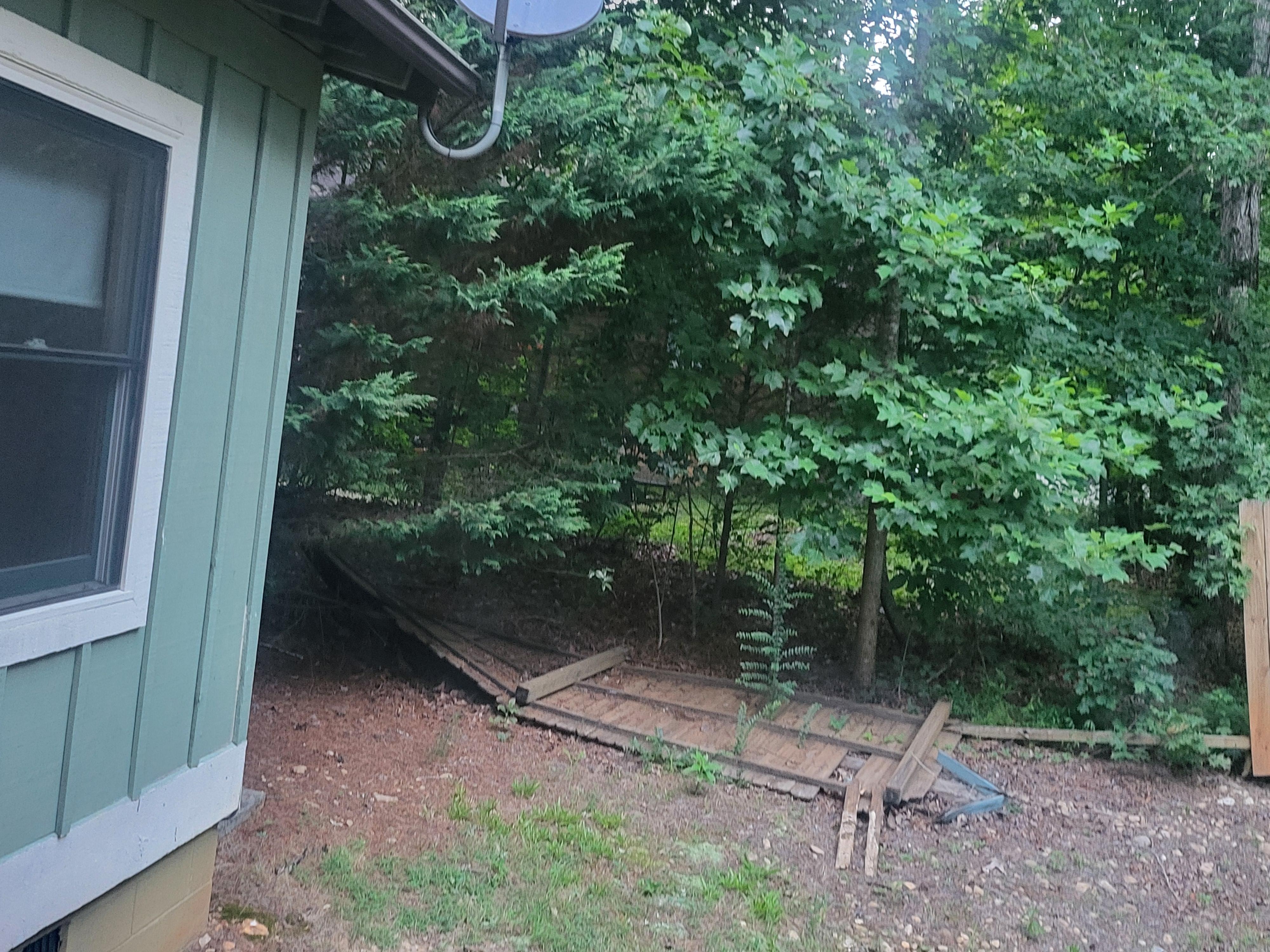 This is a back yard with fallen fence. It doesn't look very picturesque. 