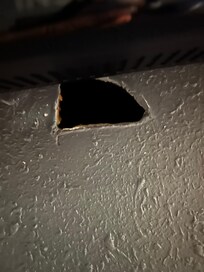 Hole in wall under tv.