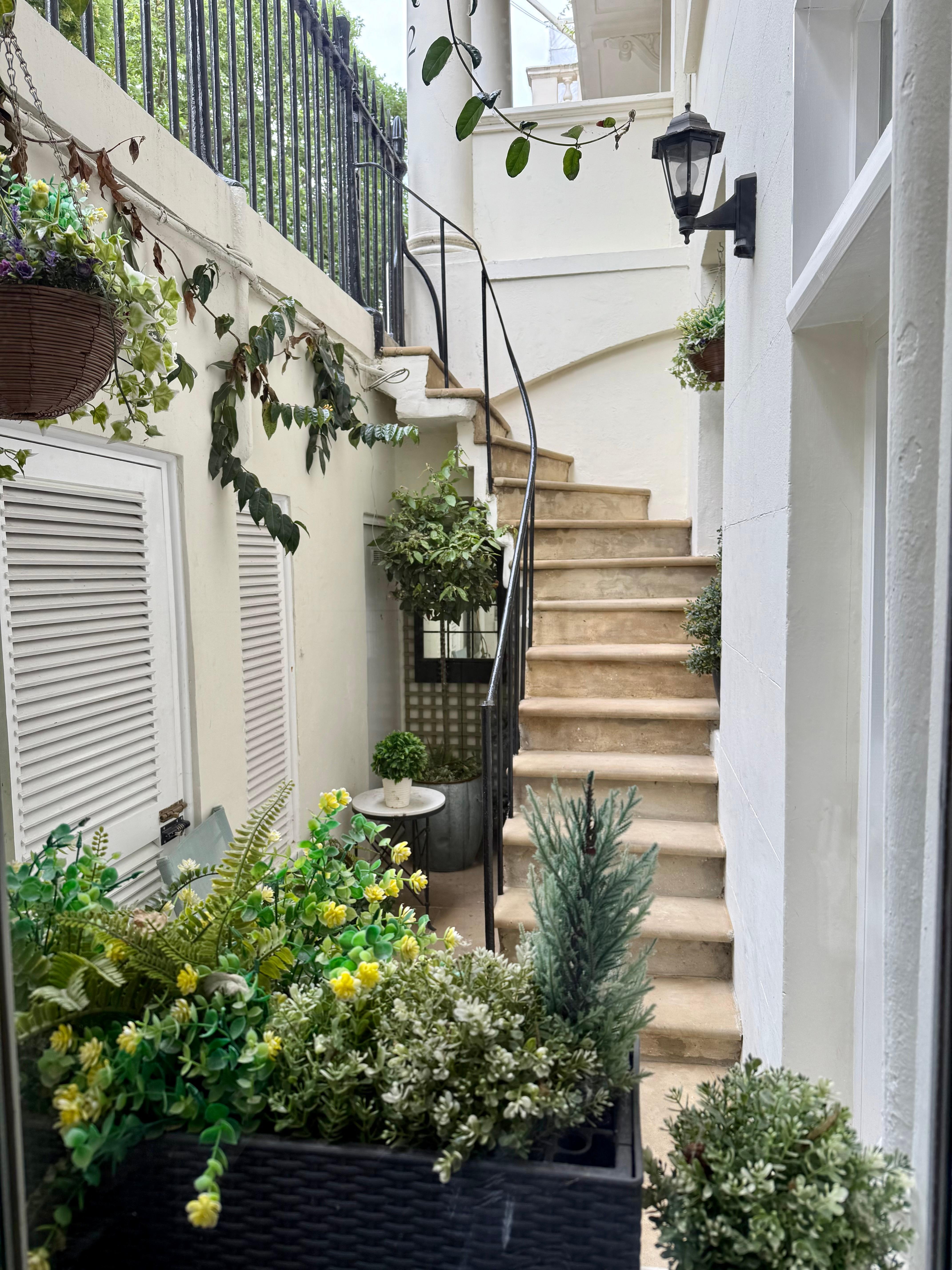 View from kitchen window of little courtyard and stairs leading to sidewalk
