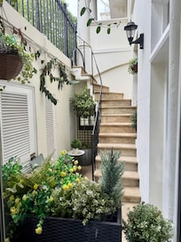 View from kitchen window of little courtyard and stairs leading to sidewalk