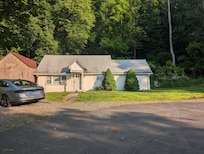 View from the driveway. There's a neighboring house on the right