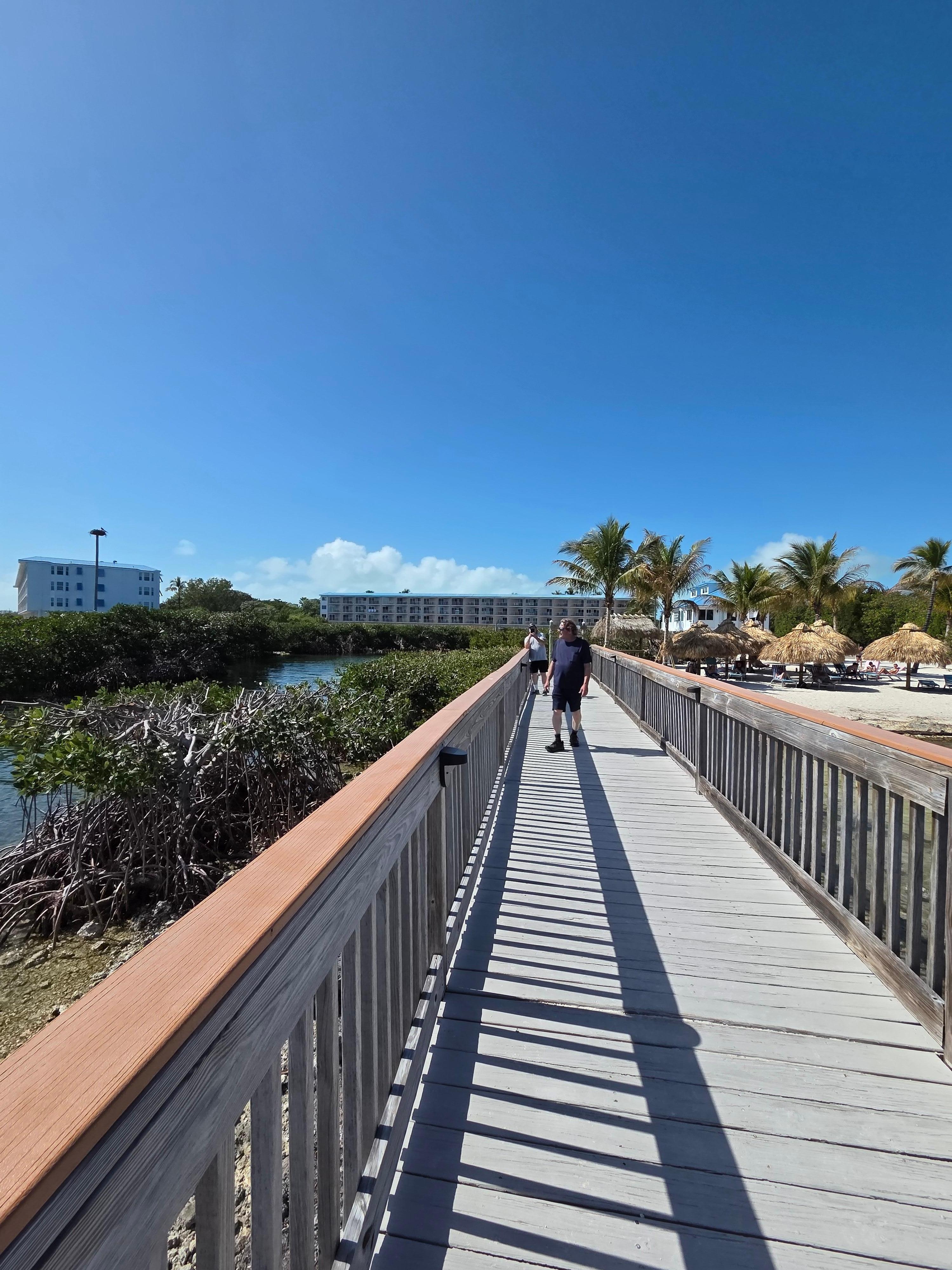 Walkway at beach with 2 condo units in background.