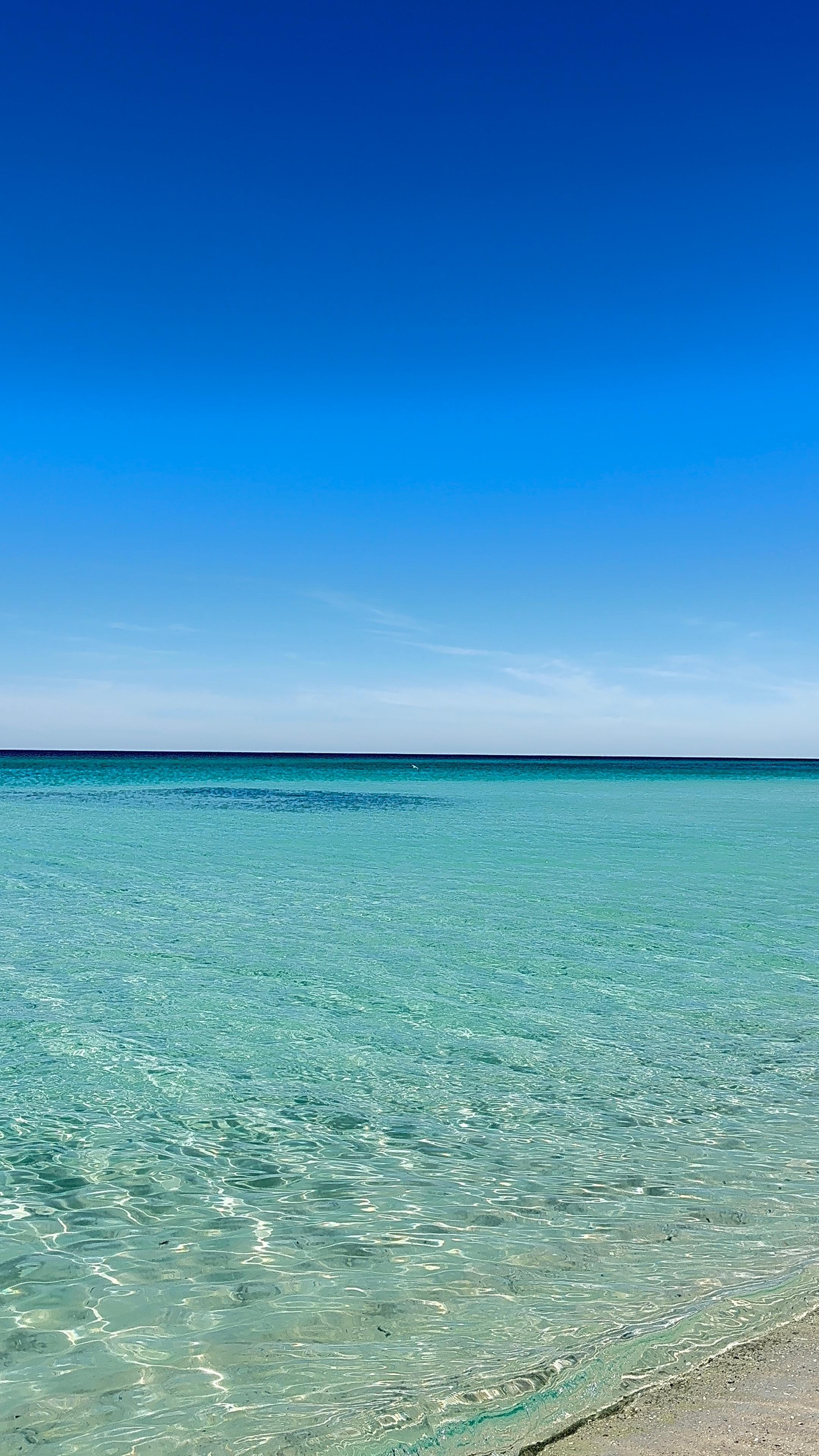 Crystal clear and dynamically blue water in front of our beach chairs