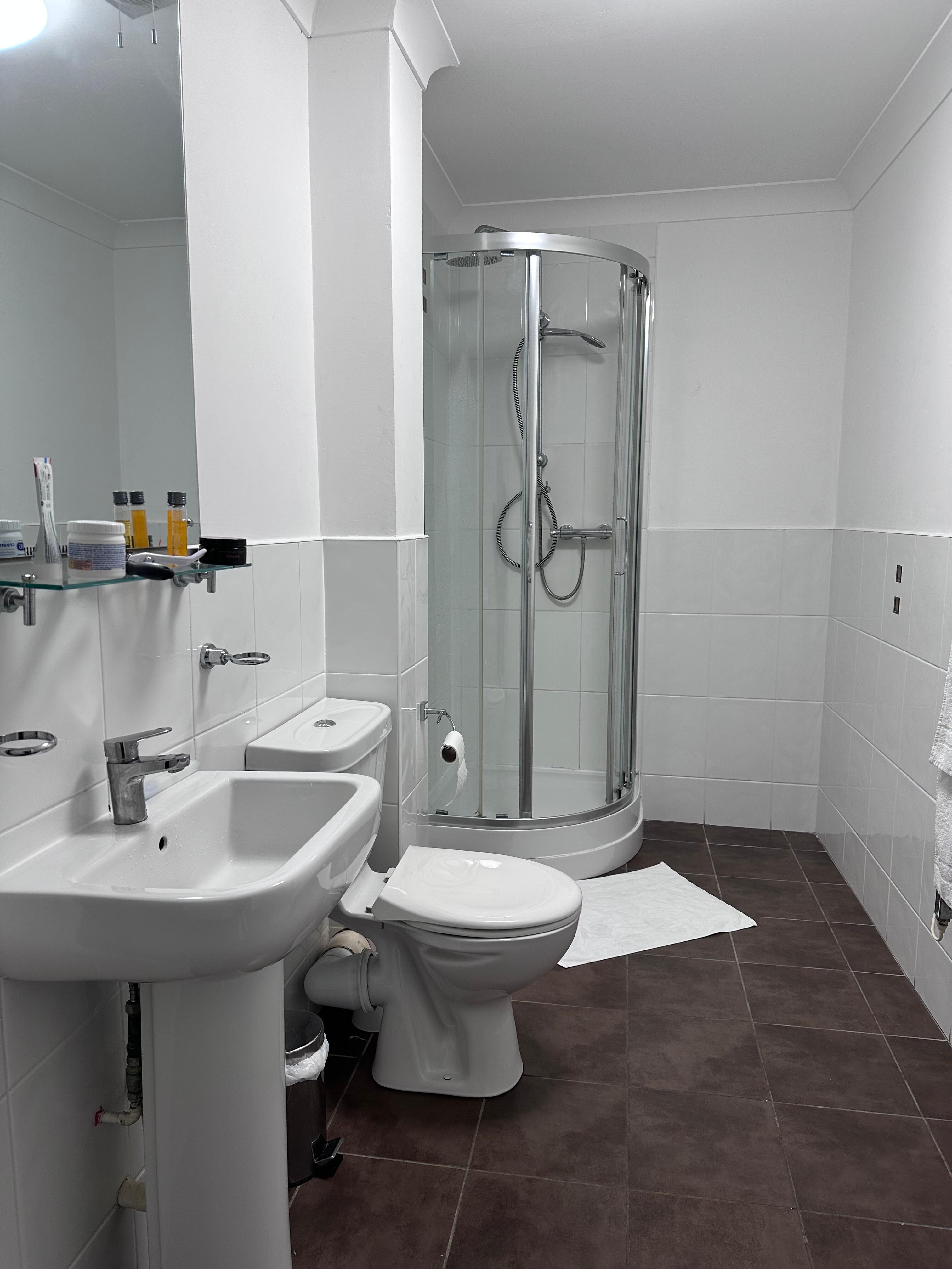 Long spacious bathroom but a tiny shower cubicle 