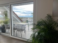 Dachterrasse mit Tisch und Stühlen, Pergola als Sonnenschutz vorhanden.
