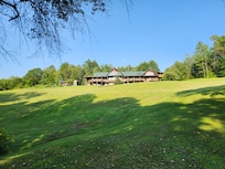 Located atop a beautiful hill surrounded by forest and mountains in the distance.