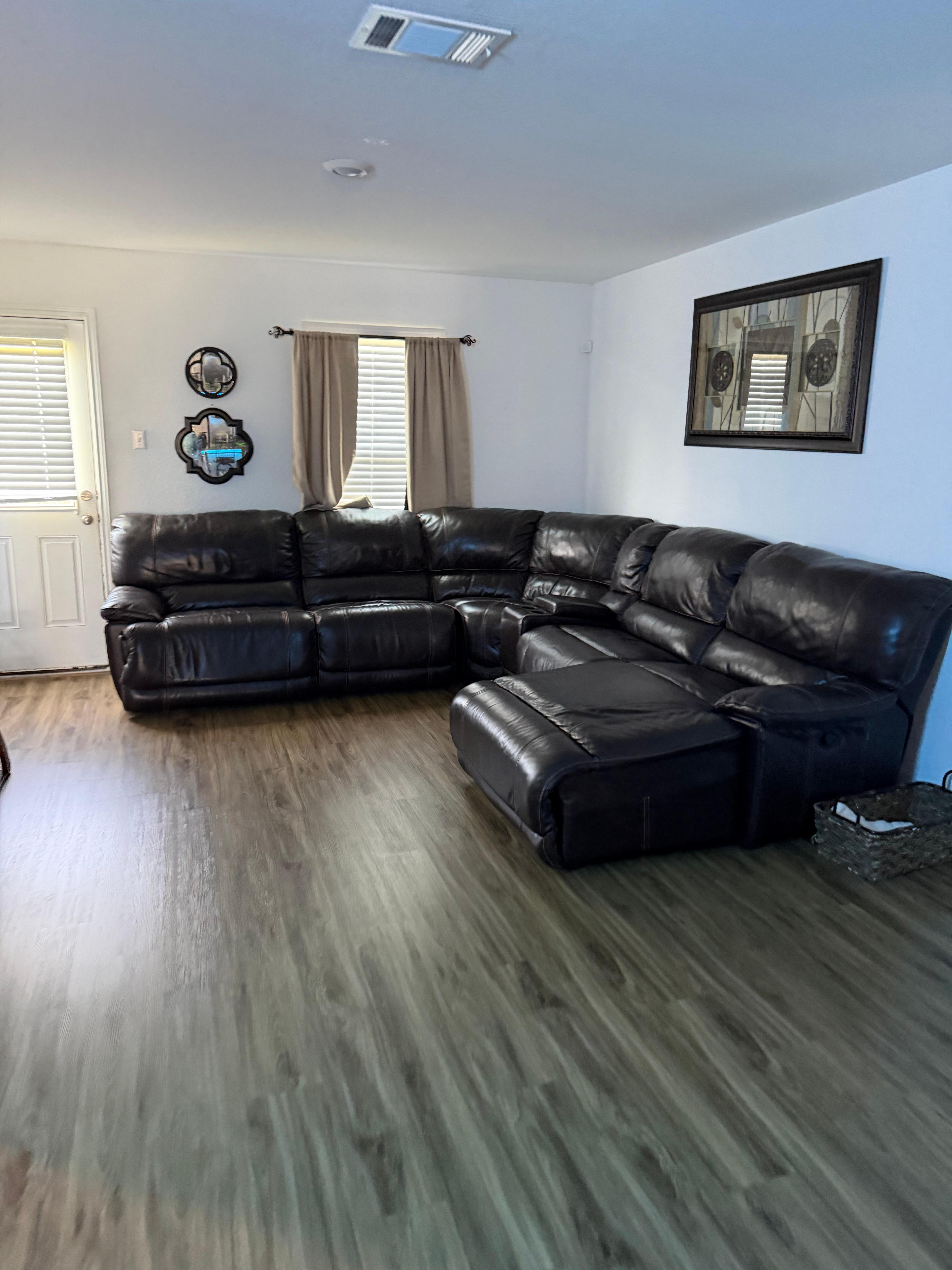 Living room w/leather sectional reclining couch and blanket basket! 