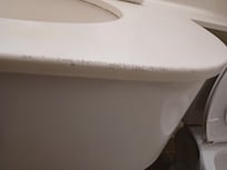 Sink in bathroom gouged and dirty.