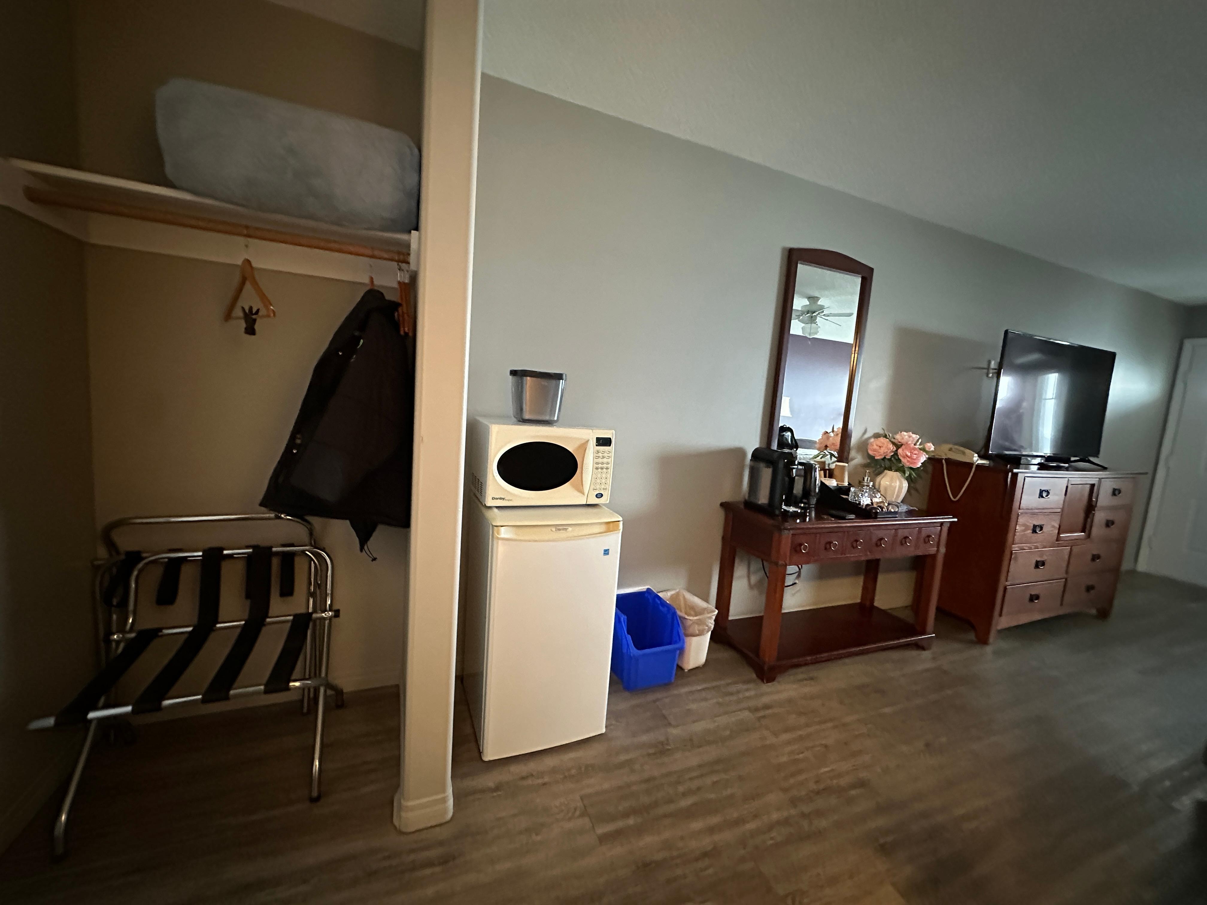 Open closet, bar fridge, microwave, coffee station, dresser and TV. 