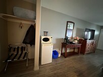 Open closet, bar fridge, microwave, coffee station, dresser and TV.