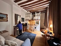 Cozy living area with adjoining kitchen. Note the exposed wooden beams.