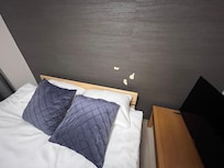 Holes on the wall with eyelashes on TV stand and fingernails in the walls