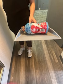 Trash that I got out of the room while housekeeping held the dust pan.